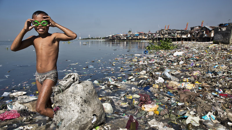 A kid literally swimming in waste.