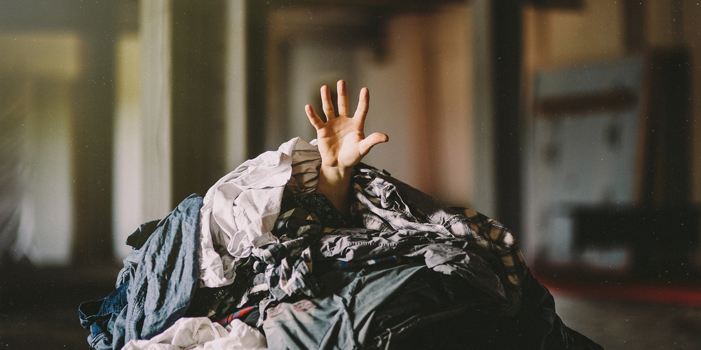 human covered in a pile of laundry
