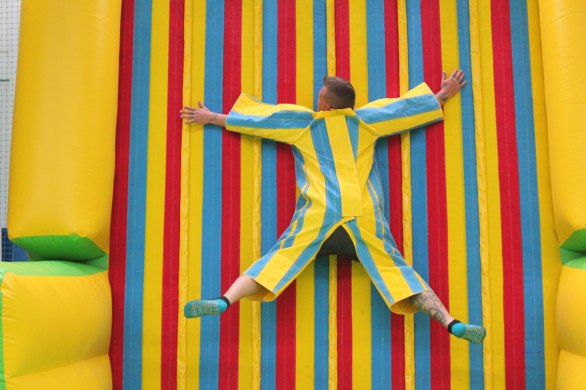 man sticks to velcro wall