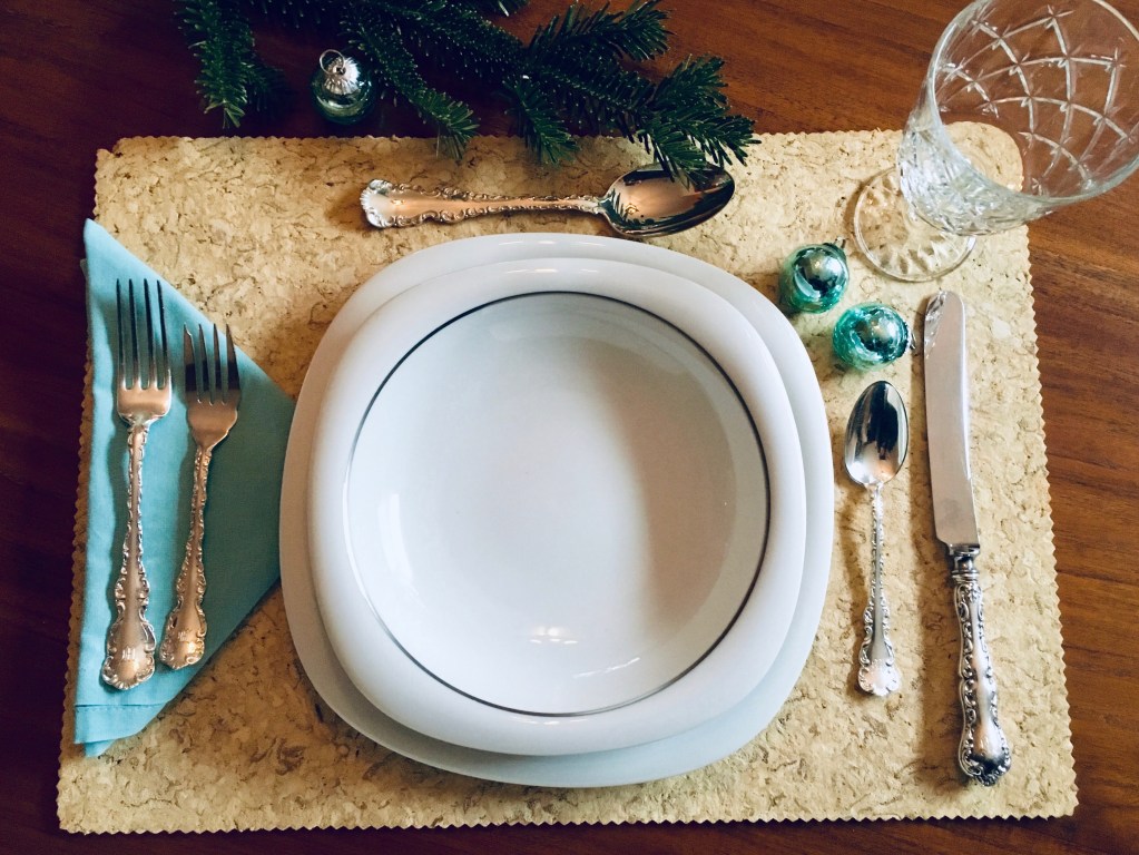 Festive place setting, complete with cutlery, plates, and glasses. Avoid disposables to help celebrate a low-waste holiday season.