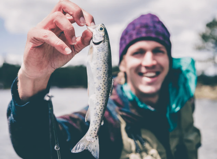 Guy holding up a fish he caught!