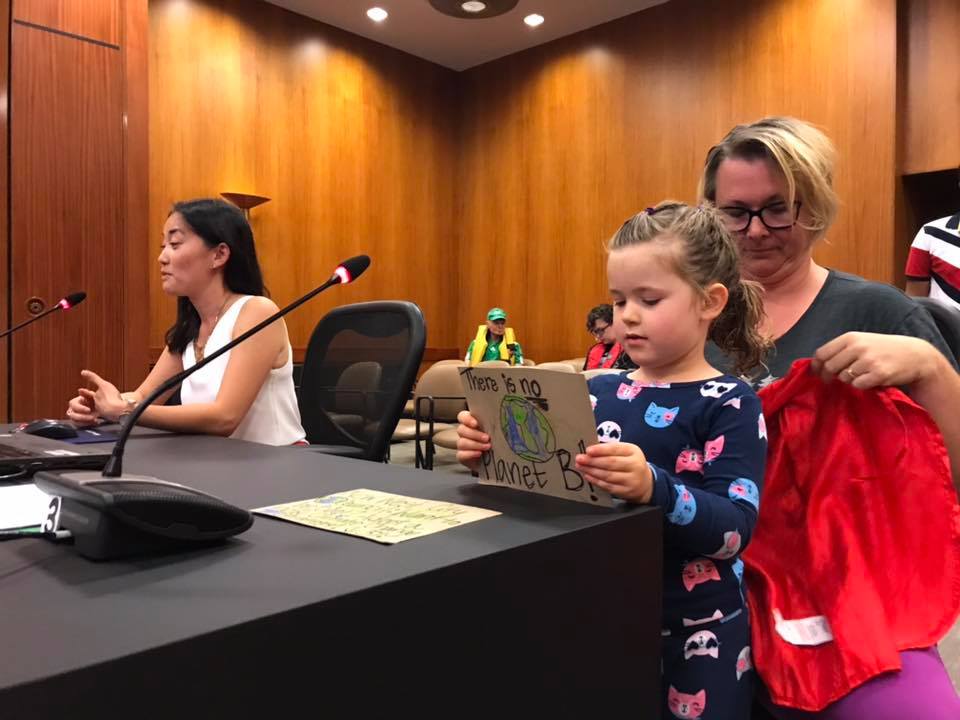 A Little One Displays her signage at the meeting.